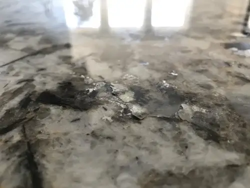 Polished slab showing uneven gloss and dull dark spots