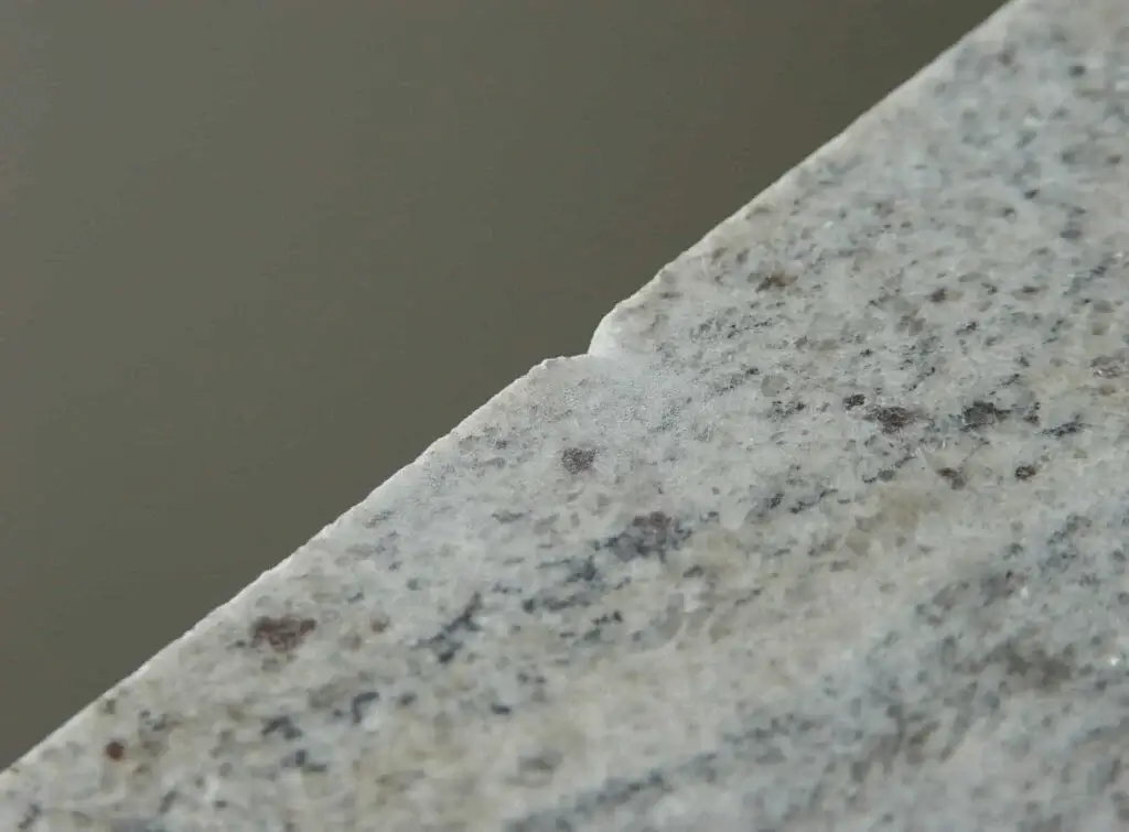 Severe edge chipping and blowouts on a stone slab