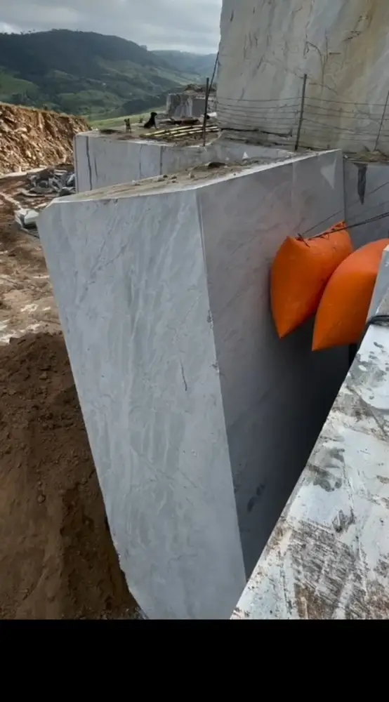 Worker sliding thin protective steel plates on both sides of a deflated air pushing bag before inserting it into the rock kerf