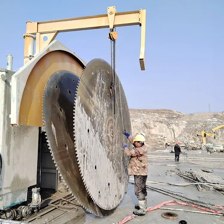 Worker using a wire brush to clean the mounting flanges of a large circular saw blade